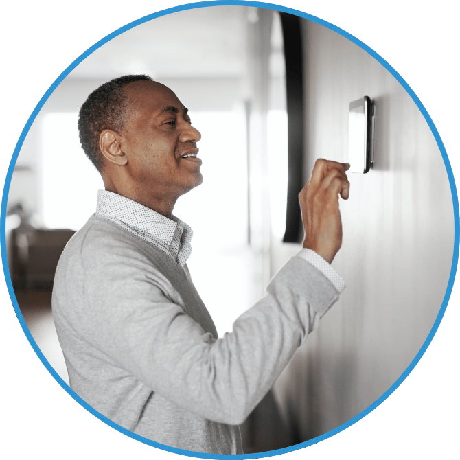 A man adjusts a thermostat.