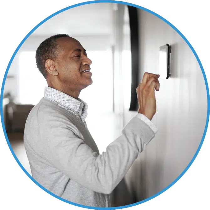 A man adjusts a thermostat.