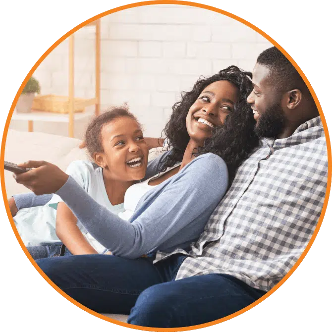 A family is shown on the couch watching TV