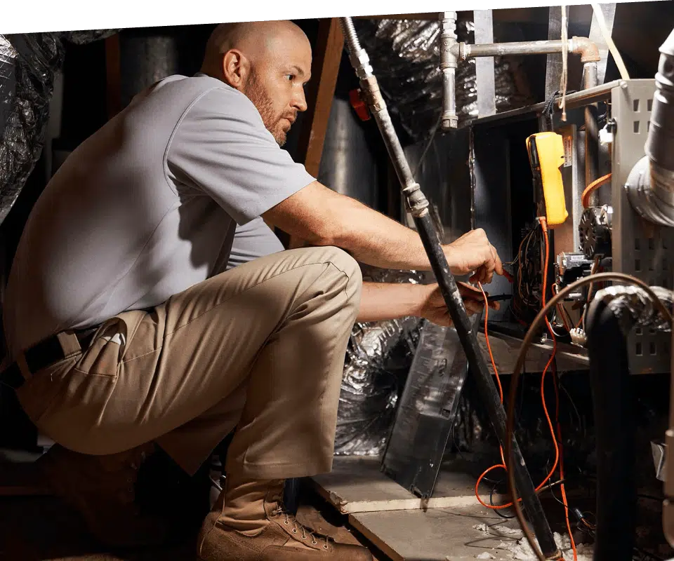 A HVAC contractor works on a furnace.