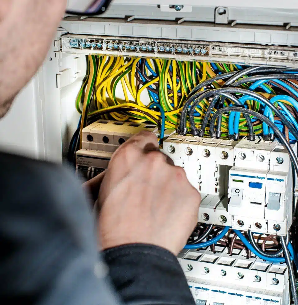 An electrician works on an electrical box