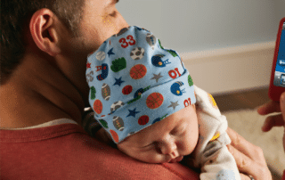 A man holds a sleeping baby